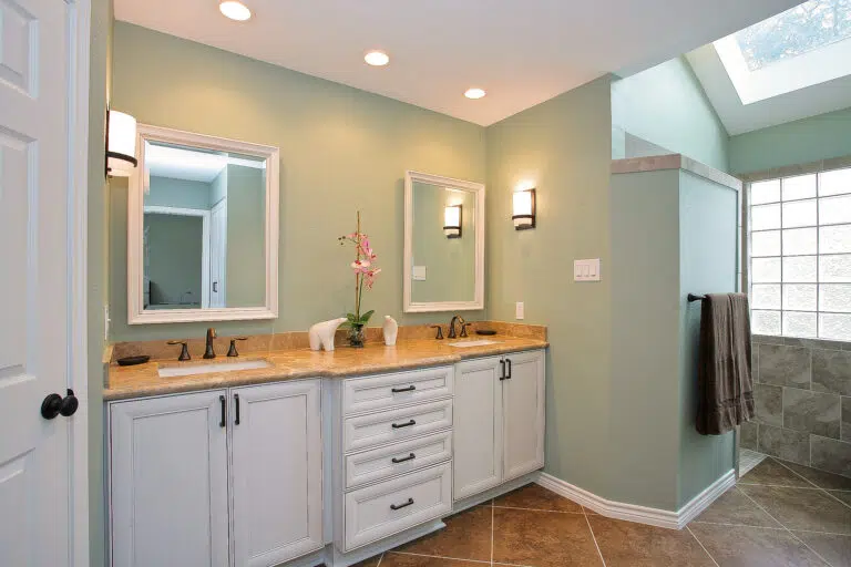Spring Texas Bathroom Remodelers beautiful bathroom with updated neutral green walls, wood sink, and updated light fixtures