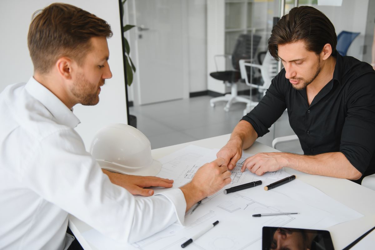 two men talking blueprints