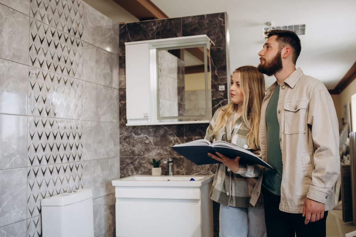 young couple choosing tiles at building market